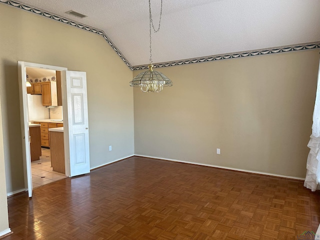 empty room featuring an inviting chandelier, lofted ceiling, a textured ceiling, and dark parquet flooring