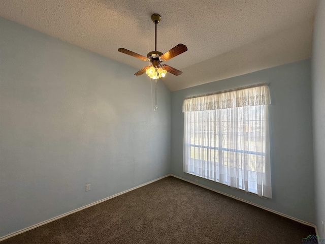 unfurnished room with vaulted ceiling, ceiling fan, a textured ceiling, and dark carpet