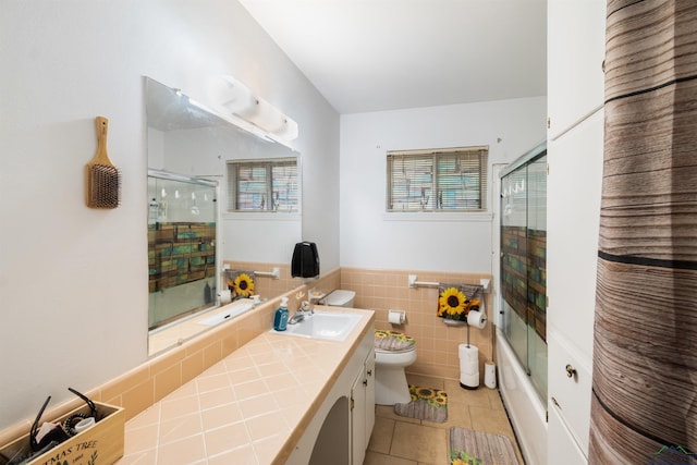 1115 Fuller Dr, Longview, TX 75602 - full bathroom featuring tile patterned flooring, vanity, tile walls, wainscoting, and shower / bath combination with glass door