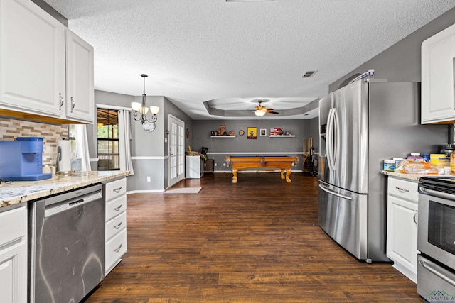 kitchen featuring appliances with stainless steel finishes, dark wood-style floors, a textured ceiling, and visible vents