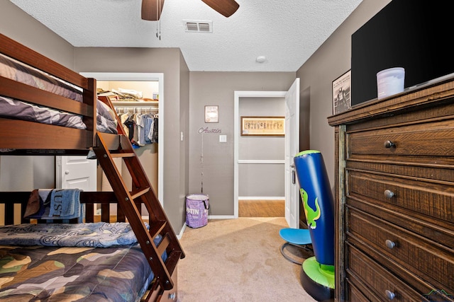 carpeted bedroom featuring ceiling fan, visible vents, baseboards, a closet, and a spacious closet