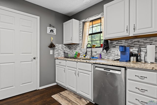 kitchen featuring tasteful backsplash, stainless steel dishwasher, a sink, white cabinets, and dark wood-type flooring