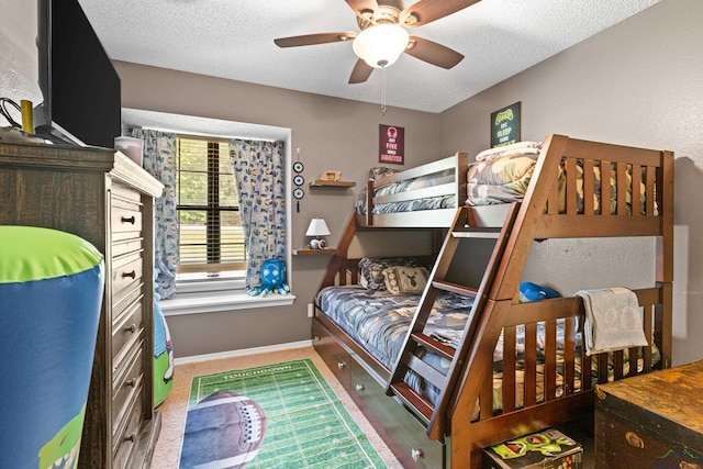 bedroom with baseboards, a ceiling fan, and a textured ceiling