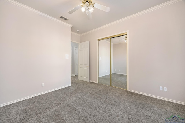 unfurnished bedroom featuring ceiling fan, a closet, carpet floors, and crown molding