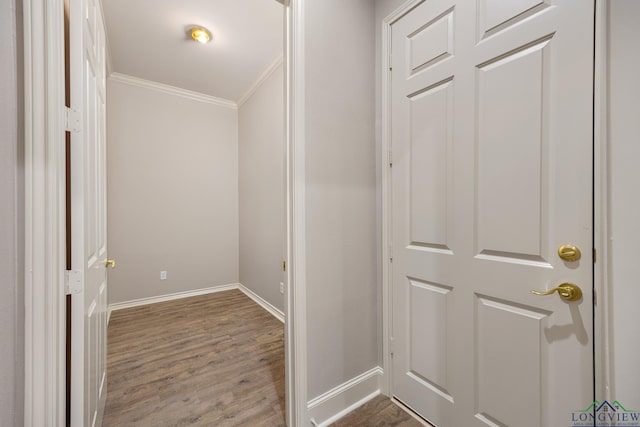 corridor with ornamental molding and hardwood / wood-style floors