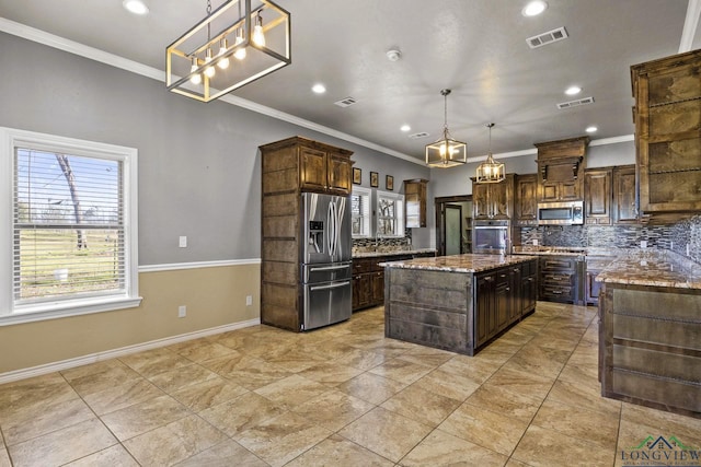 5796 Hwy 271 S, Pittsburg, TX 75686 - kitchen featuring appliances with stainless steel finishes, ornamental molding, decorative backsplash, light stone countertops, and a kitchen island