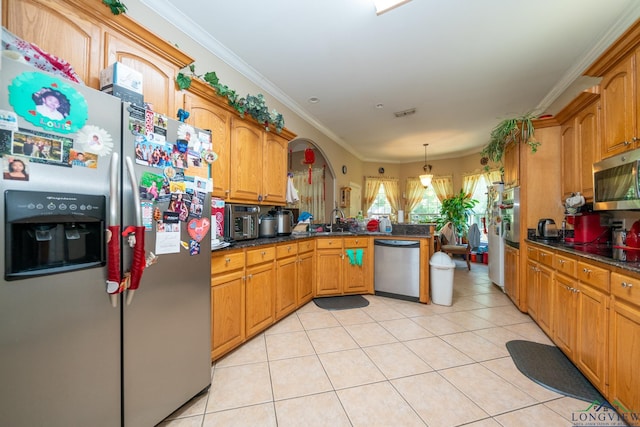 kitchen with sink, ornamental molding, appliances with stainless steel finishes, decorative light fixtures, and kitchen peninsula