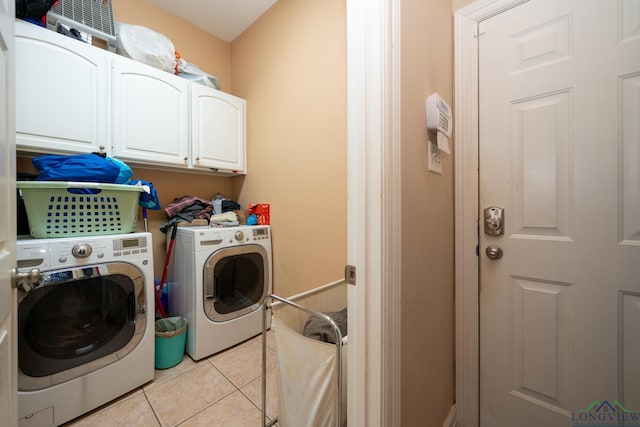 washroom with cabinets, light tile patterned floors, and washing machine and dryer