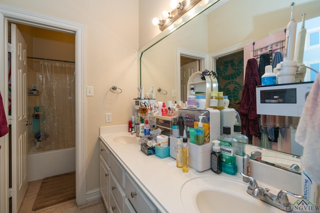 bathroom featuring tile patterned floors, vanity, and shower / bath combo with shower curtain