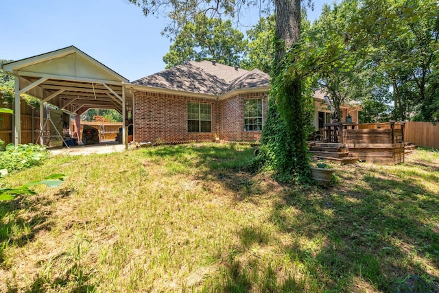 back of house with a carport and a lawn