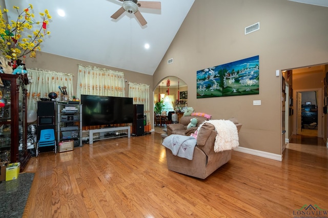 living room with hardwood / wood-style flooring, high vaulted ceiling, and ceiling fan