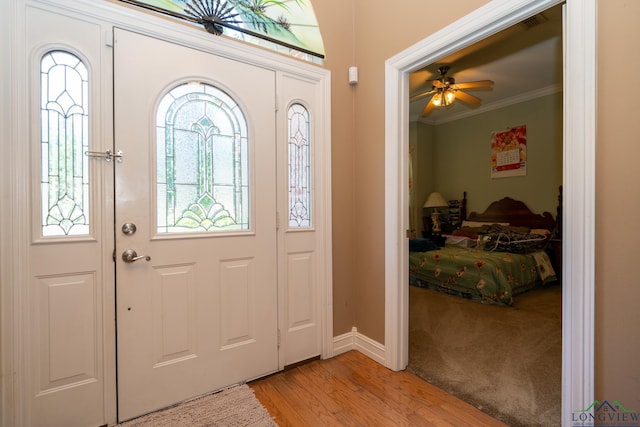 entrance foyer featuring ceiling fan, light hardwood / wood-style flooring, and ornamental molding