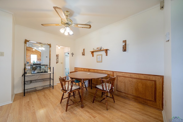 dining space with ceiling fan, crown molding, and light hardwood / wood-style flooring