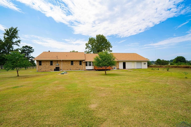 back of house featuring a garage and a yard