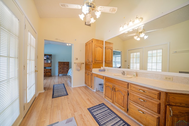 bathroom with hardwood / wood-style floors, vanity, vaulted ceiling, and ceiling fan