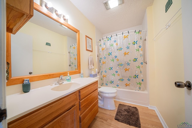 full bathroom featuring vanity, toilet, a textured ceiling, wood-type flooring, and shower / tub combo