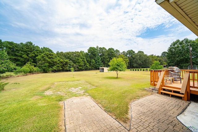 view of yard with a deck and a patio