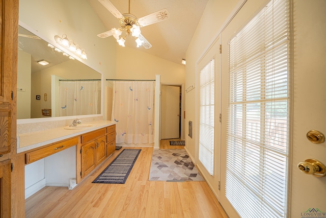 bathroom with a shower with curtain, vanity, vaulted ceiling, ceiling fan, and wood-type flooring