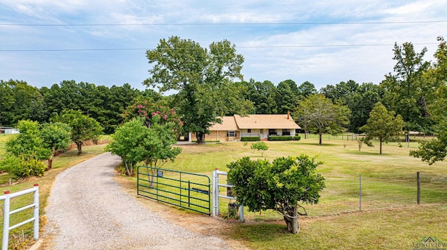 view of front of home with a front yard and a rural view