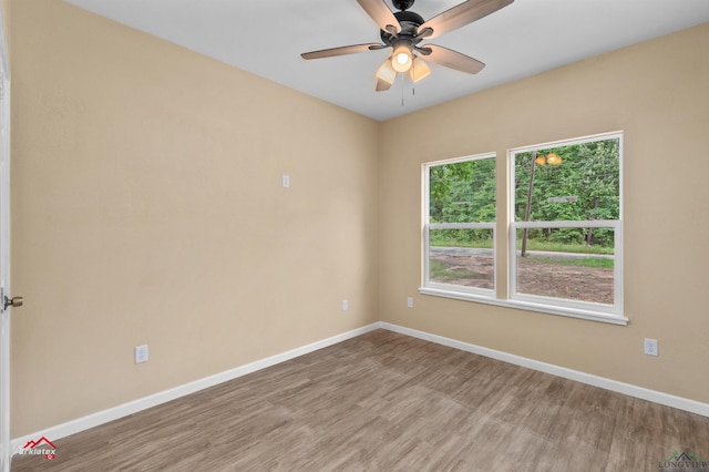 1406 Commerce, Kilgore, TX 75662 - spare room featuring baseboards, wood finished floors, and ceiling fan