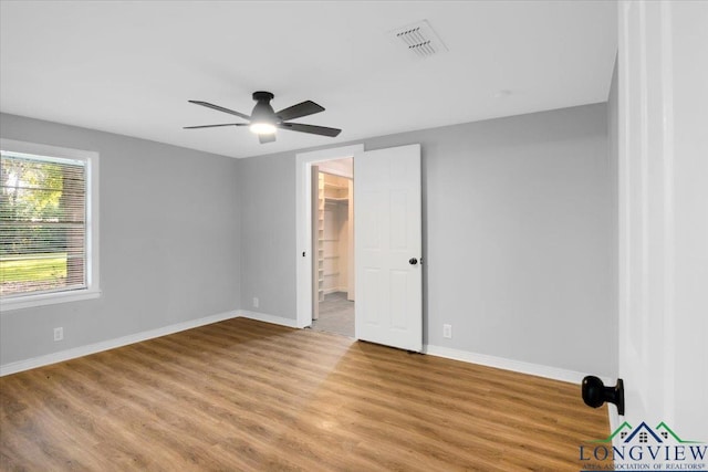 1012 Premier Rd, Longview, TX 75604 - unfurnished bedroom with wood finished floors, baseboards, and ceiling fan