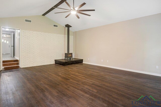 1012 Premier Rd, Longview, TX 75604 - unfurnished living room with a ceiling fan, a wood stove, wood finished floors, baseboards, and brick wall