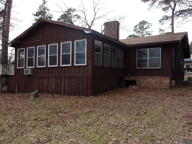 view of side of home featuring board and batten siding and a chimney