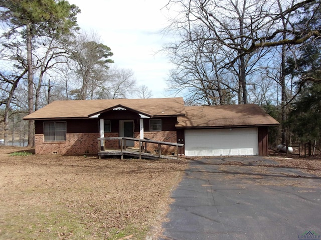 ranch-style house featuring a garage, crawl space, brick siding, and driveway