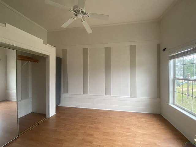 interior space with ornamental molding, ceiling fan, and light hardwood / wood-style floors