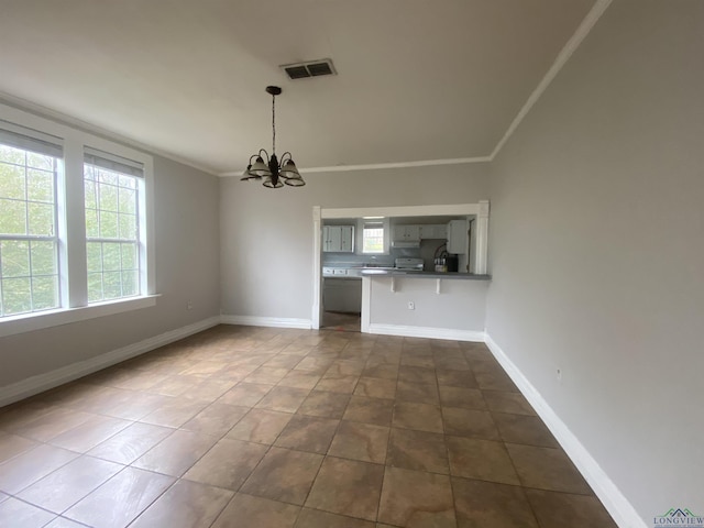 unfurnished dining area with an inviting chandelier, crown molding, tile patterned flooring, and a wealth of natural light