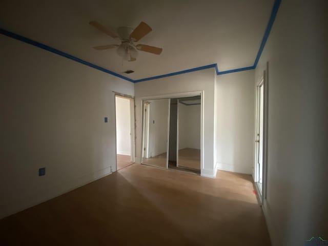 unfurnished bedroom featuring crown molding, a closet, and ceiling fan