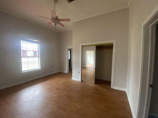 unfurnished bedroom with ornamental molding, ceiling fan, and dark hardwood / wood-style flooring