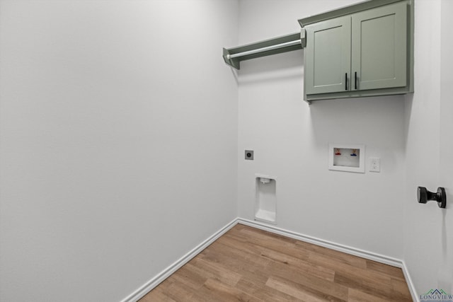 clothes washing area featuring light wood-type flooring, washer hookup, electric dryer hookup, and cabinets