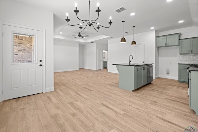 kitchen with stainless steel dishwasher, backsplash, decorative light fixtures, ceiling fan with notable chandelier, and sink