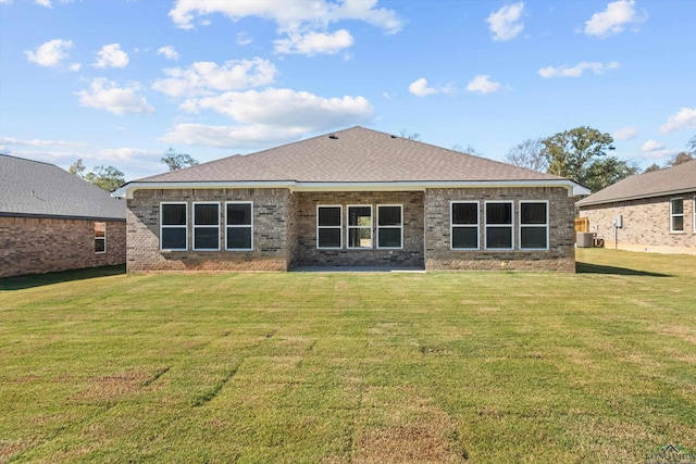 rear view of property with a lawn and cooling unit