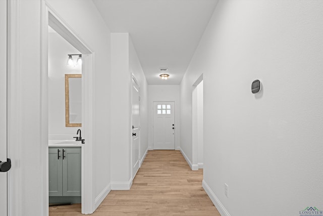 corridor featuring light hardwood / wood-style flooring and sink