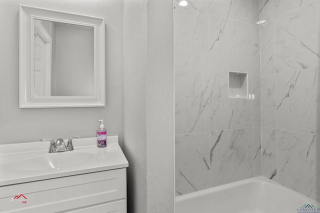 bathroom featuring vanity and tiled shower / bath