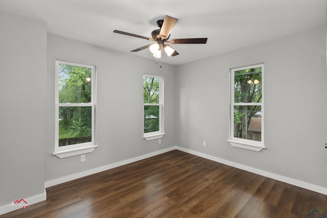 empty room with ceiling fan and dark hardwood / wood-style flooring