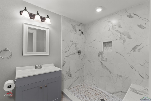 bathroom featuring a tile shower and vanity