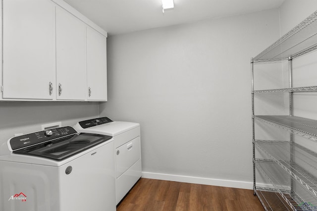 laundry room featuring cabinets, dark hardwood / wood-style floors, and washer and clothes dryer