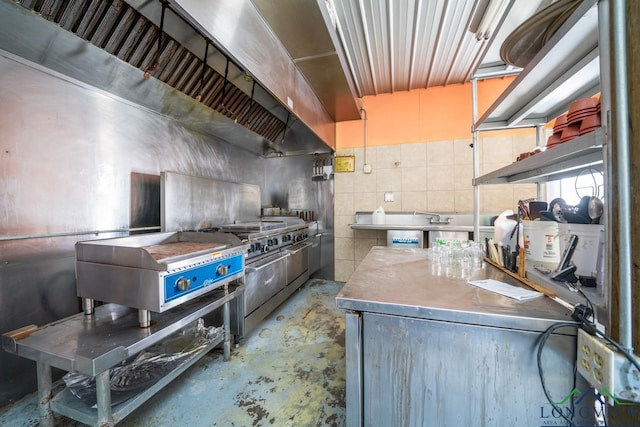 kitchen with stainless steel counters, wall chimney range hood, high end stainless steel range, and concrete floors