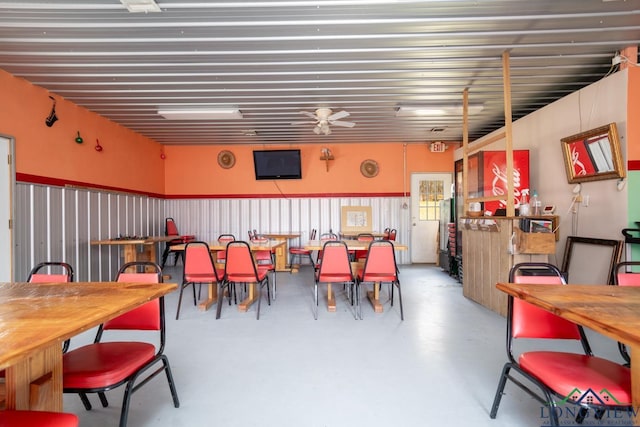 dining area with ceiling fan and concrete flooring