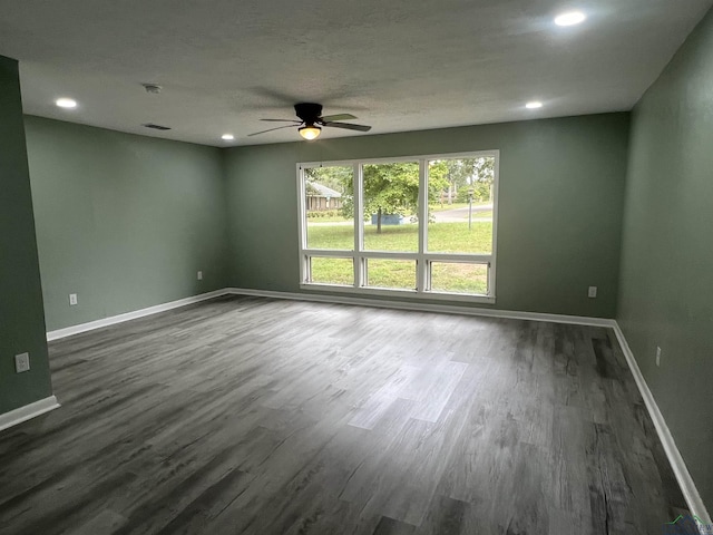 unfurnished room with ceiling fan and dark wood-type flooring