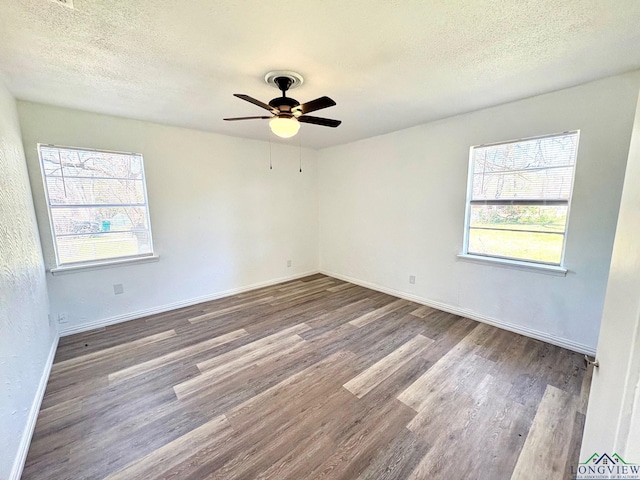 spare room featuring baseboards, a textured ceiling, ceiling fan, and wood finished floors
