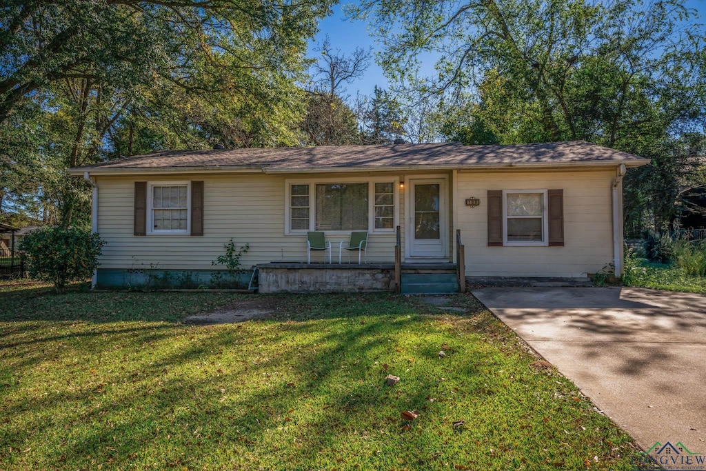 ranch-style home with covered porch and a front yard