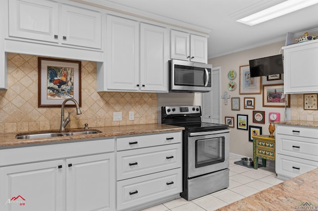 589 County Road 183, Carthage, TX 75633 - kitchen with stainless steel appliances, a sink, light tile patterned floors, white cabinets, and light stone counters