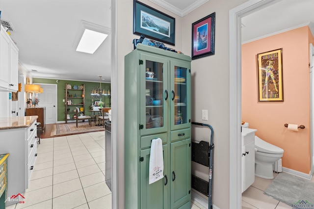 589 County Road 183, Carthage, TX 75633 - bathroom featuring ornamental molding, tile patterned floors, toilet, vanity, and baseboards