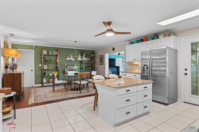 589 County Road 183, Carthage, TX 75633 - kitchen featuring stainless steel refrigerator with ice dispenser, crown molding, white cabinetry, a ceiling fan, and light tile patterned floors