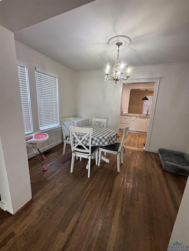 dining area with dark hardwood / wood-style floors and a notable chandelier