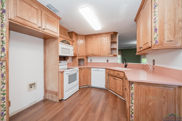 kitchen featuring a textured ceiling, sink, light hardwood / wood-style floors, and white appliances